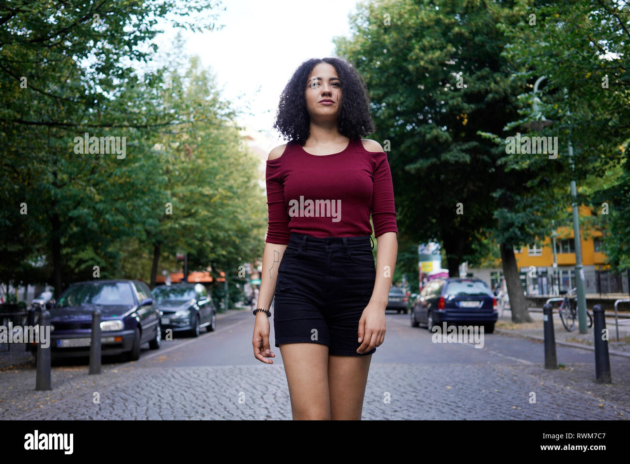 Junge Frau in der Mitte der Straße, Berlin, Deutschland Stockfoto