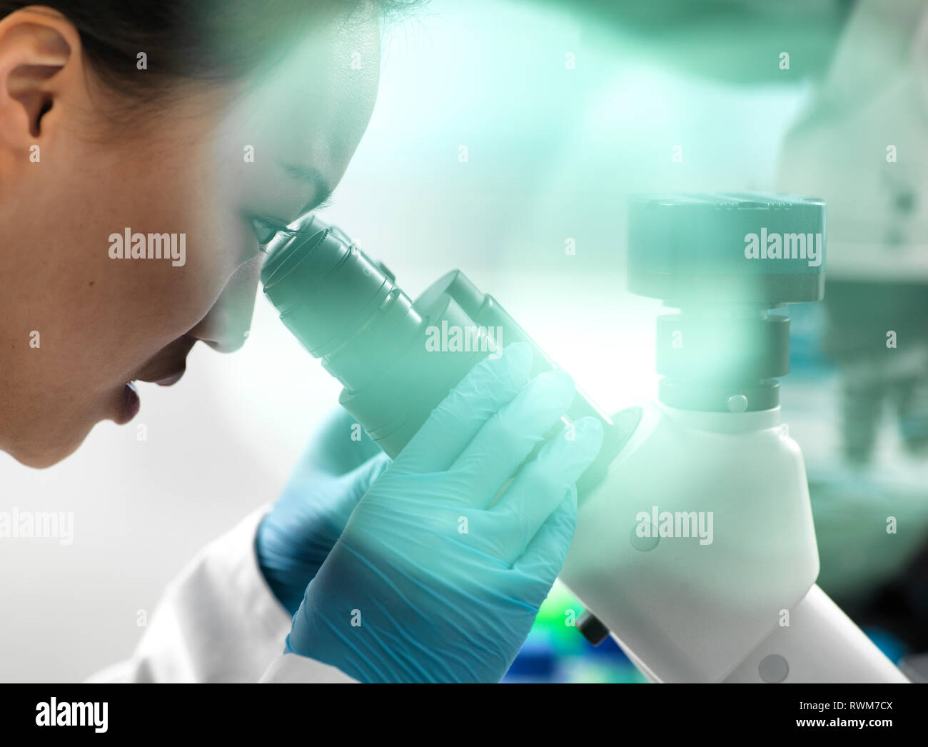 Wissenschaftler anzeigen Probe durch Mikroskop während Experiment im Labor Stockfoto