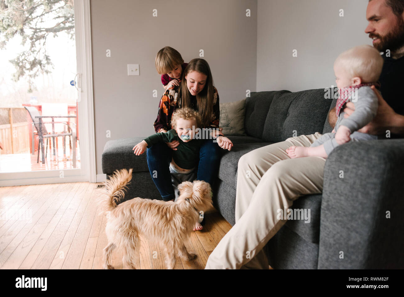 Familie und Kinder mit Hund im Wohnzimmer Stockfoto