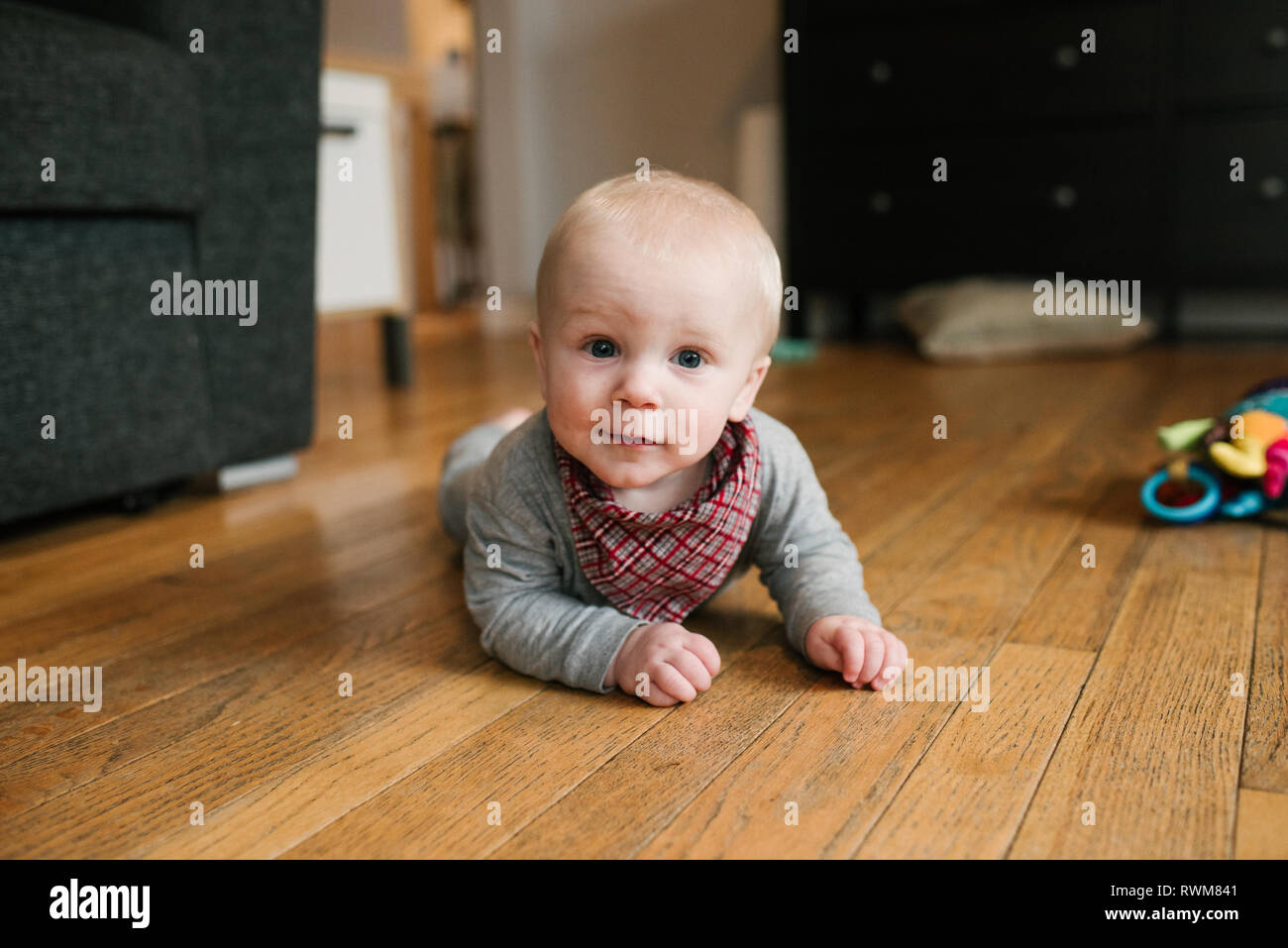 Baby Boy kriechen auf Holzboden Stockfoto