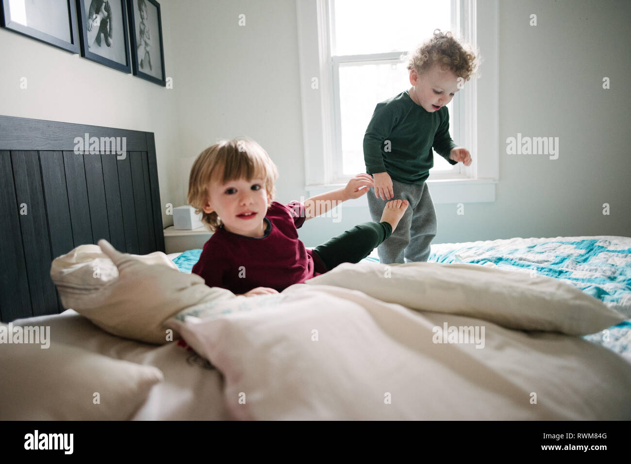 Brüder spielen im Bett Stockfoto