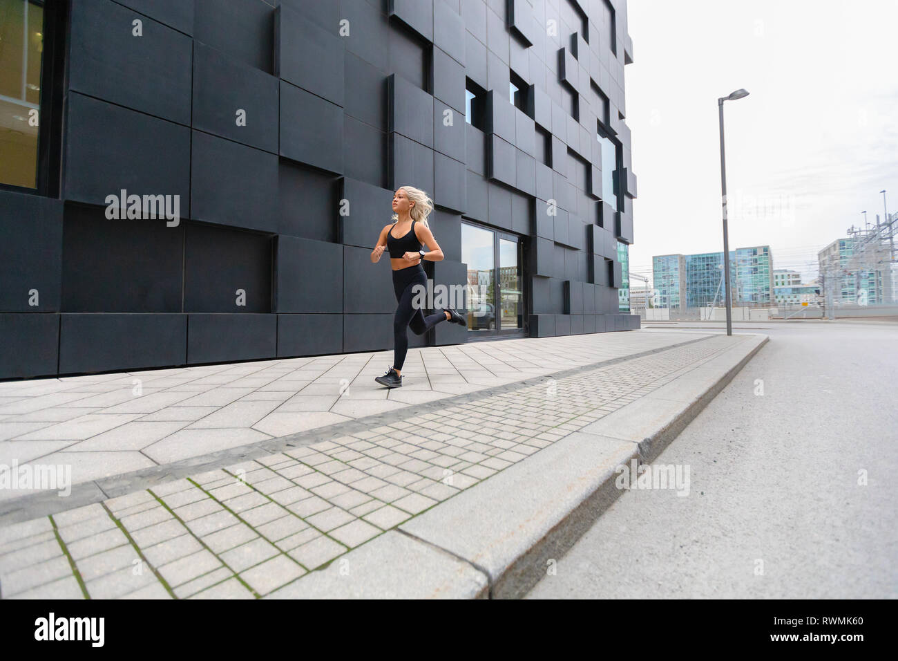 Schnell laufende Frau Sport tragen sich oben in der modernen Stadt Umgebung Stockfoto