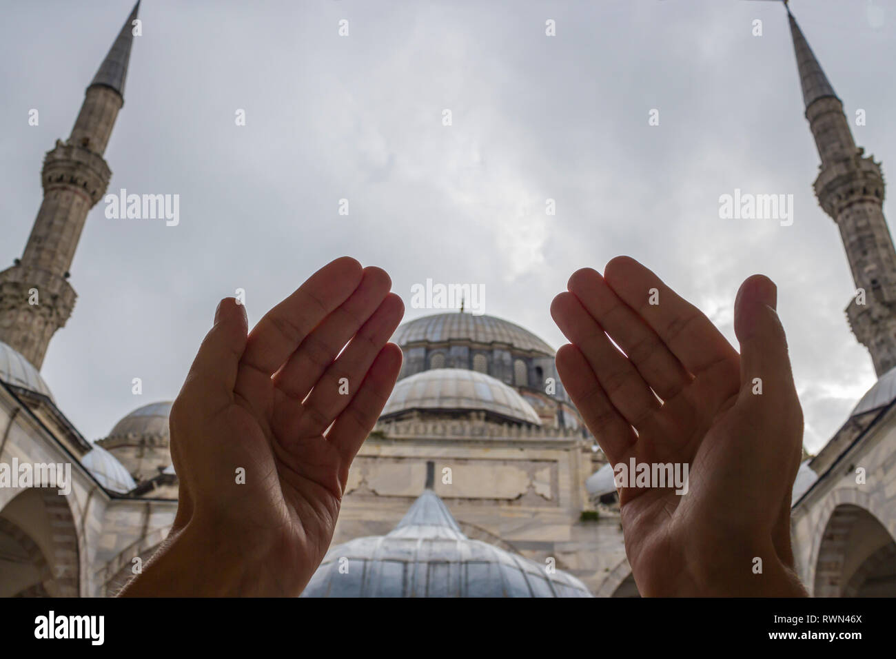 Muslimische betende Hände, Moschee und Minarett Hintergrund Stockfoto