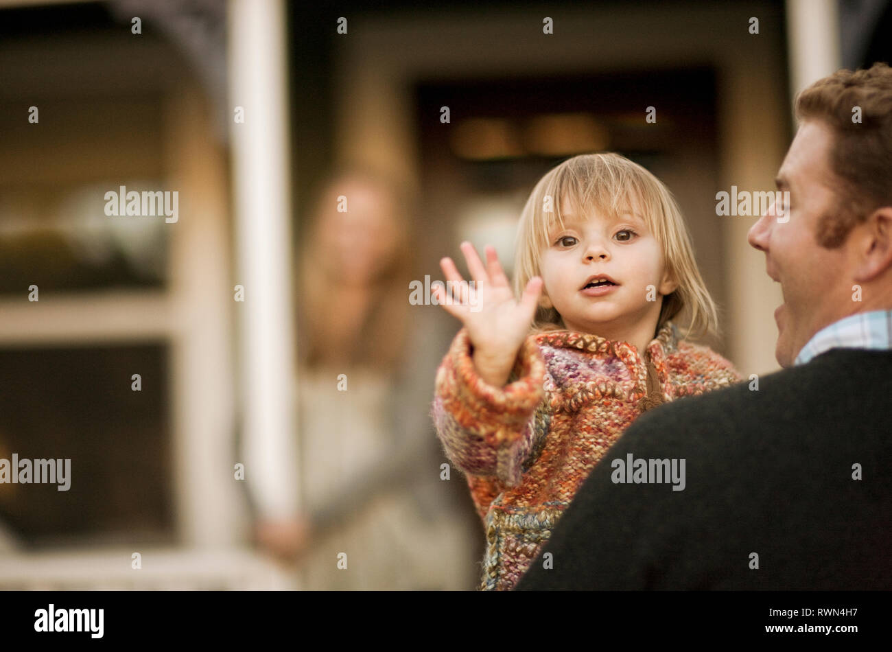 Junge Mädchen winken in die Kamera in ihrer Väter. Stockfoto