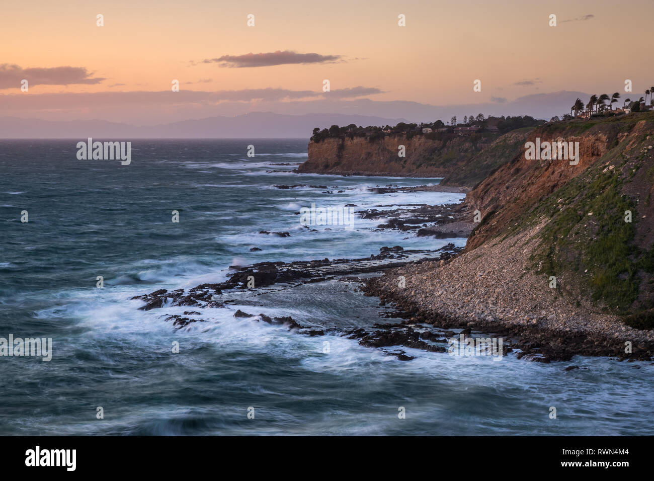 Lange Belichtung geschossen von Wellen, die in den hohen Klippen entlang der südlichen Küste von Kalifornien bei Sonnenuntergang an einem windigen Tag, goldene Bucht, Rancho Palos Verd Stockfoto