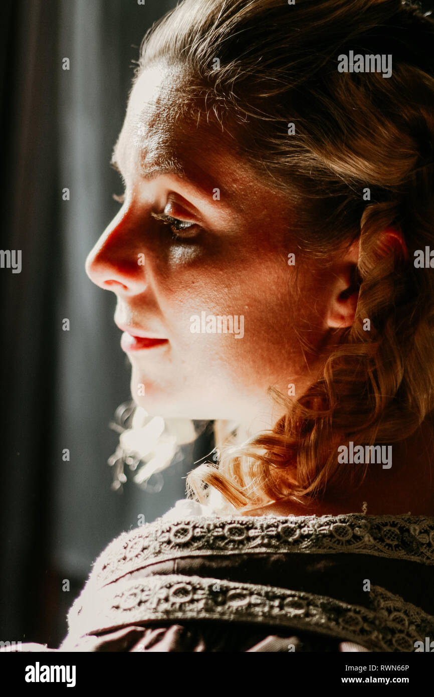 Porträt einer schönen jungen Frau in prunkvollen historischen Kleid - ihre Kleidung in Ordnung sind, die Sie trägt Perlen um den Hals & hat gewellte blonde Haare. Stockfoto