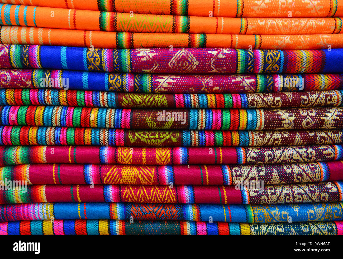 Bunter Haufen von Textilien auf dem einheimischen Markt von Otavalo, Ecuador. Diese Textilien können in den Anden gefunden werden: Peru, Bolivien, Ecuador. Stockfoto