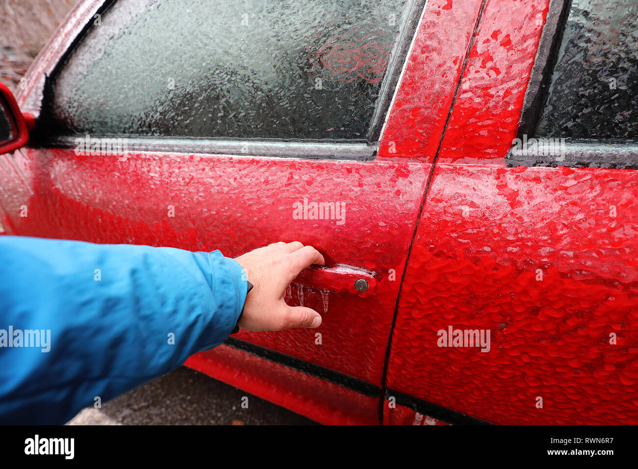Transport, Winter, Wetter, Fahrzeugkonzept. Hand auf's Auto griff im Schnee und eisigen Regen im Winter abgedeckt. Blizzard Schneefall Eisregen für Wea Stockfoto