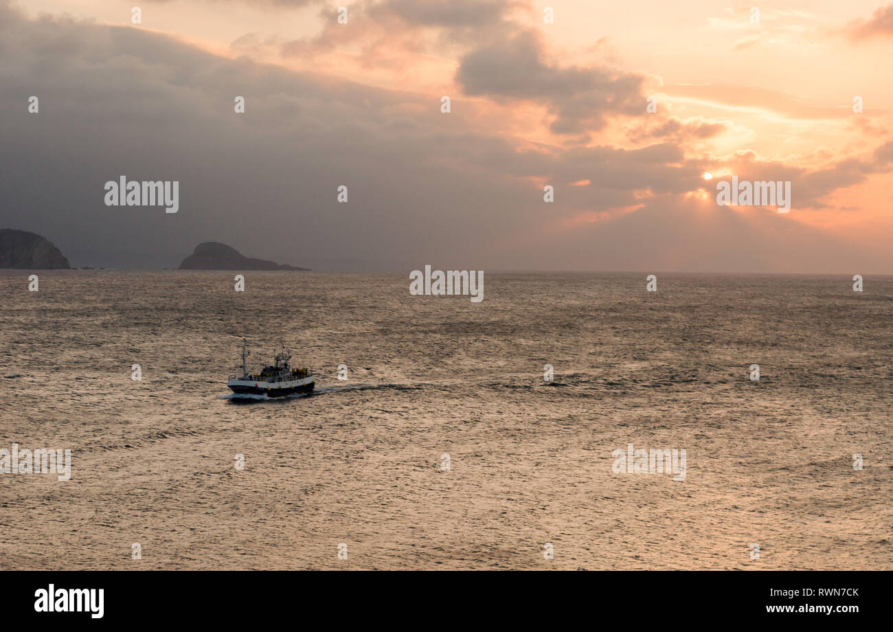 Fischerboot Eingabe bei Sonnenuntergang, in den Hafen von Avilés, Asturien, Spanien Stockfoto