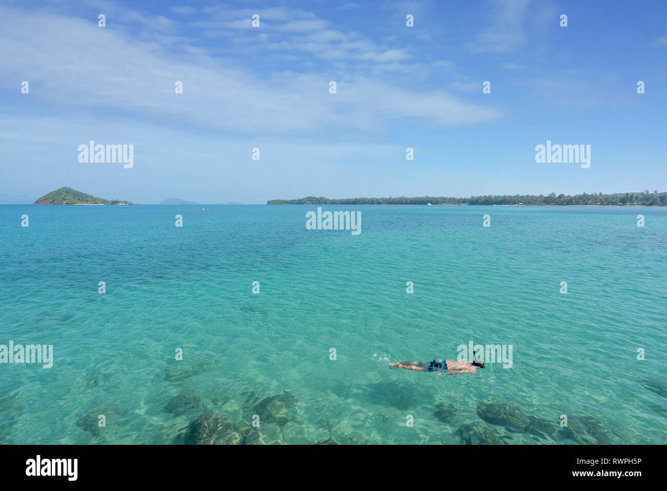 Touristen schnorcheln im kristallklaren türkisblauen Wasser in der Nähe von Tropical Resort in Phuket, Thailand. Sommer, Ferien, Reisen und Urlaub. Stockfoto