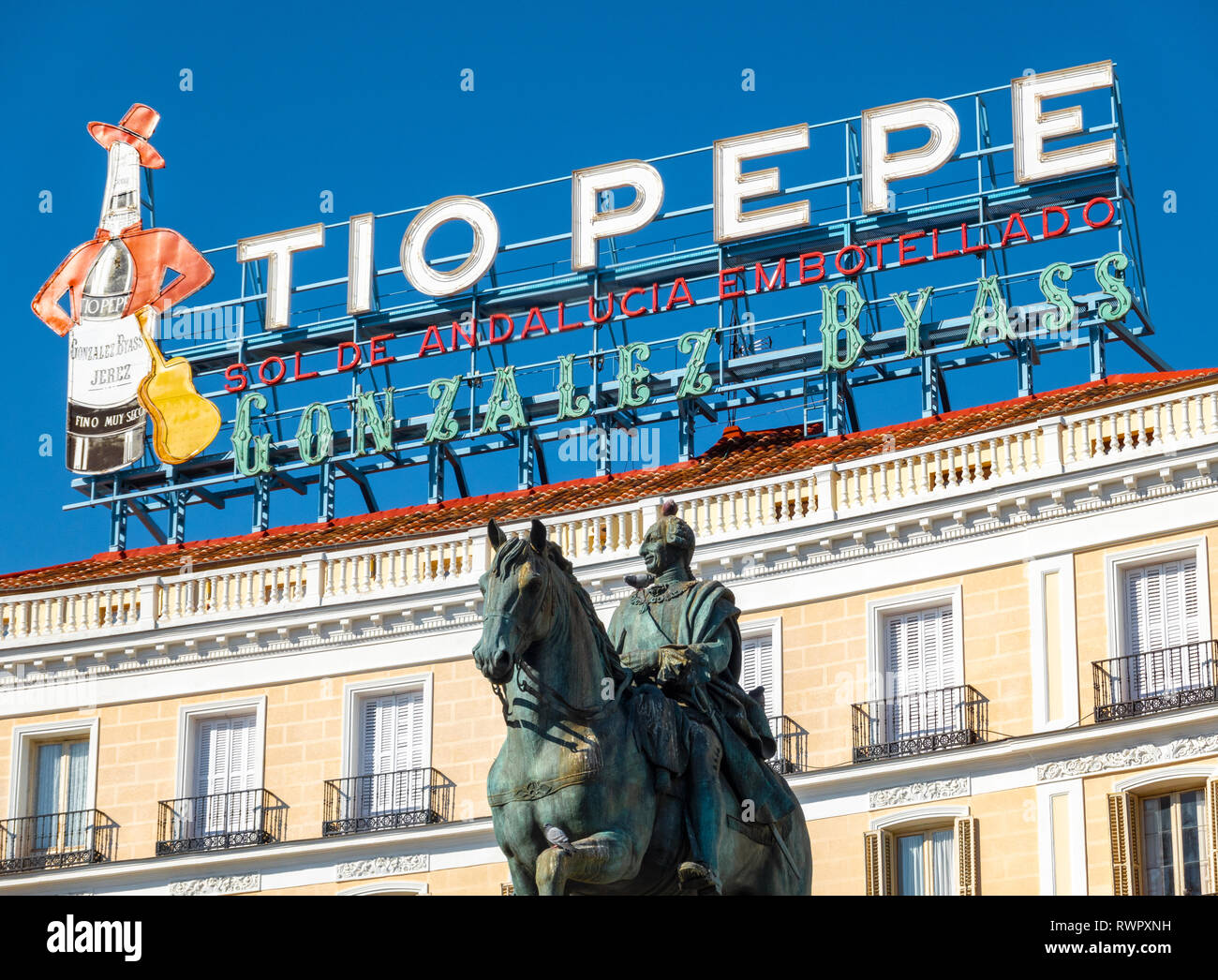 Das Wahrzeichen Tio Pepe Zeichen über Puerta del Sol Platz mit der Statue von Carlos III Karl III. von Spanien in Madrid Stockfoto