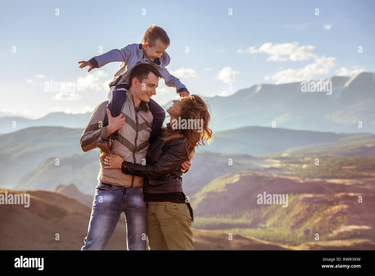 Glückliche Familie mit jungen Sohn steht gegen Berge Stockfoto