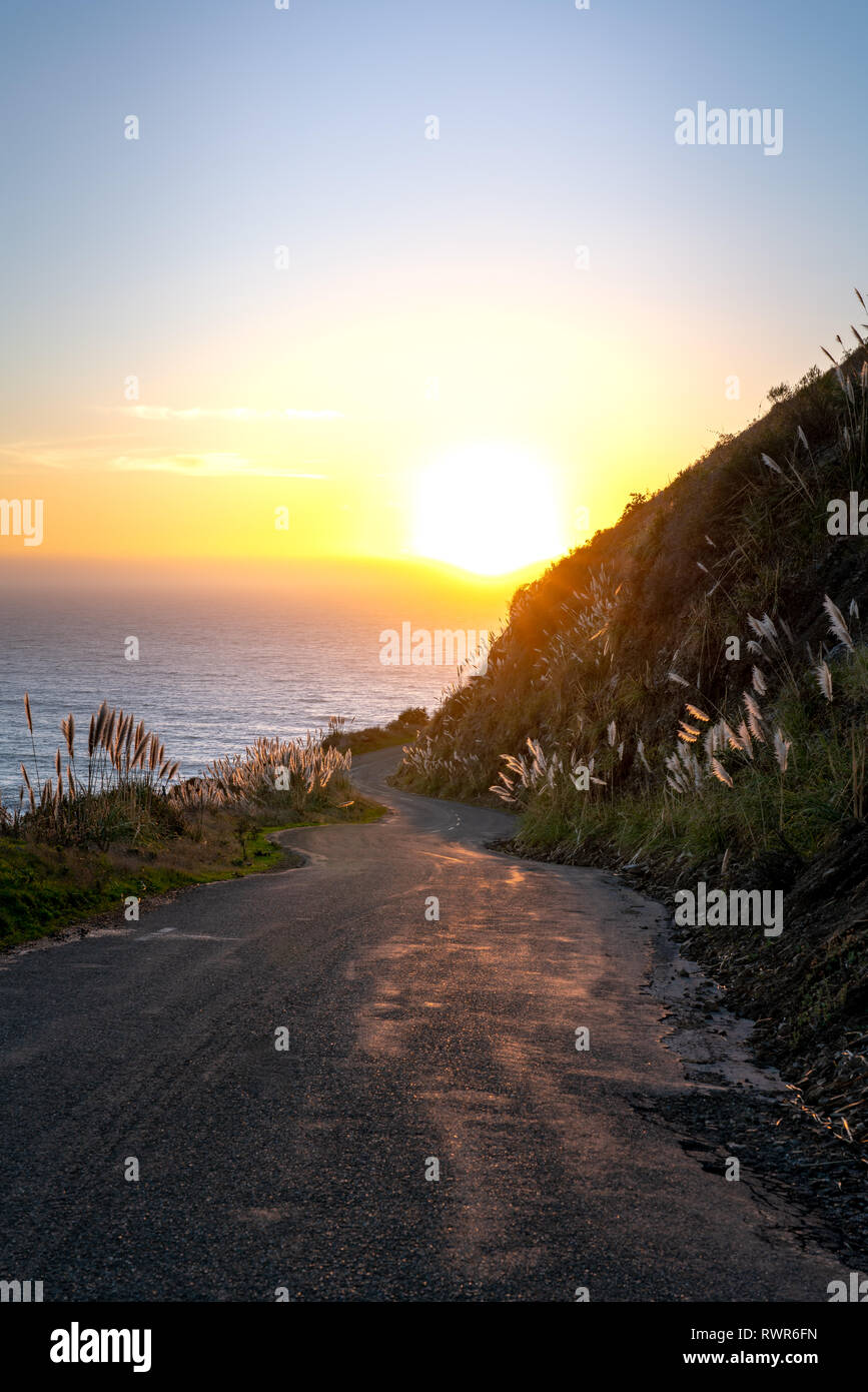 Big Sur, Kalifornien - kurvenreiche Straße führt Sie die küstennahen Hügeln auf den Pazifischen Ozean und den Sonnenuntergang. Stockfoto