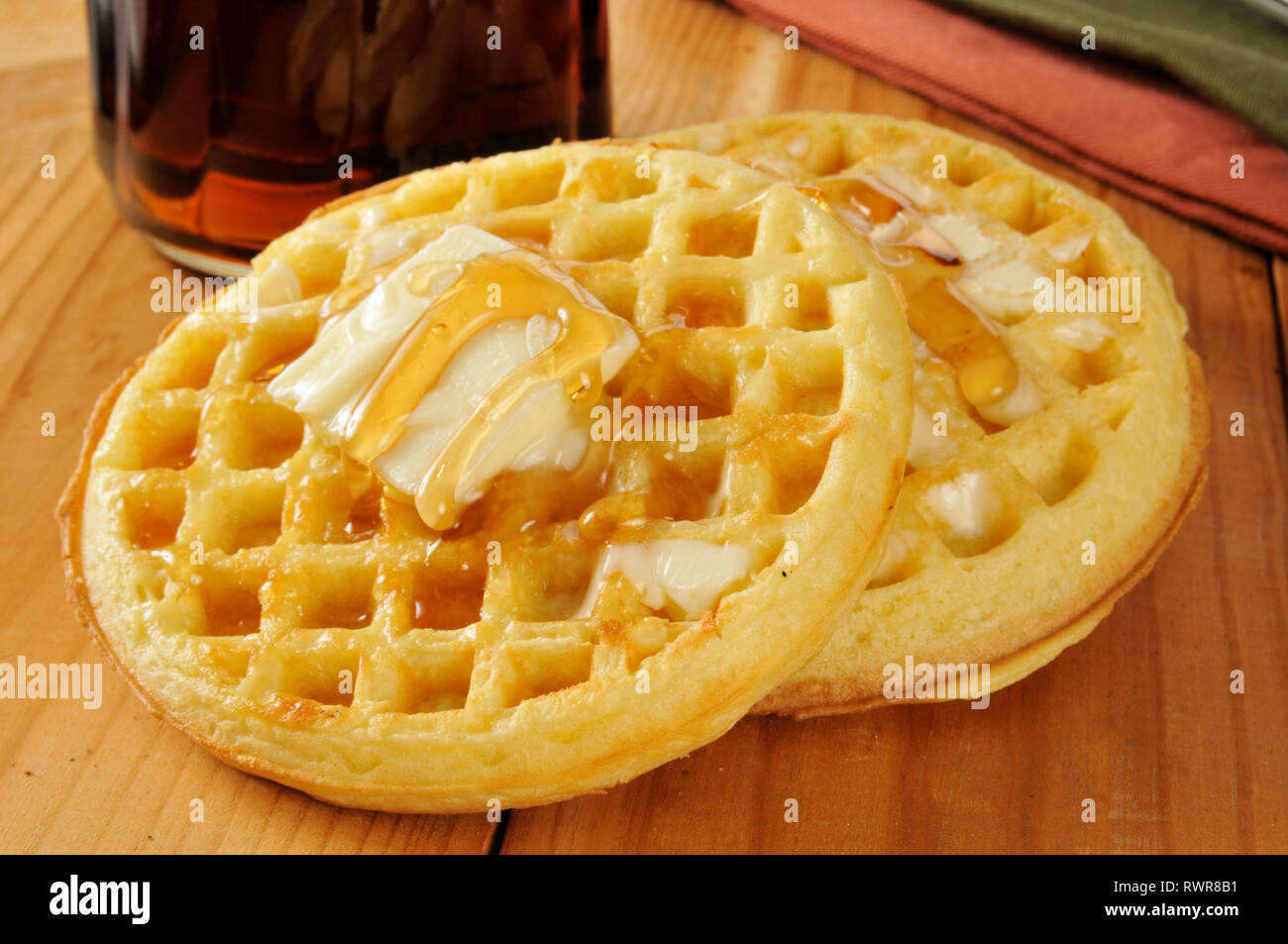 Buttermilch Waffeln mit Ahornsirup und Butter - geringe Tiefenschärfe, Schwerpunkt auf der Vorderseite Stockfoto