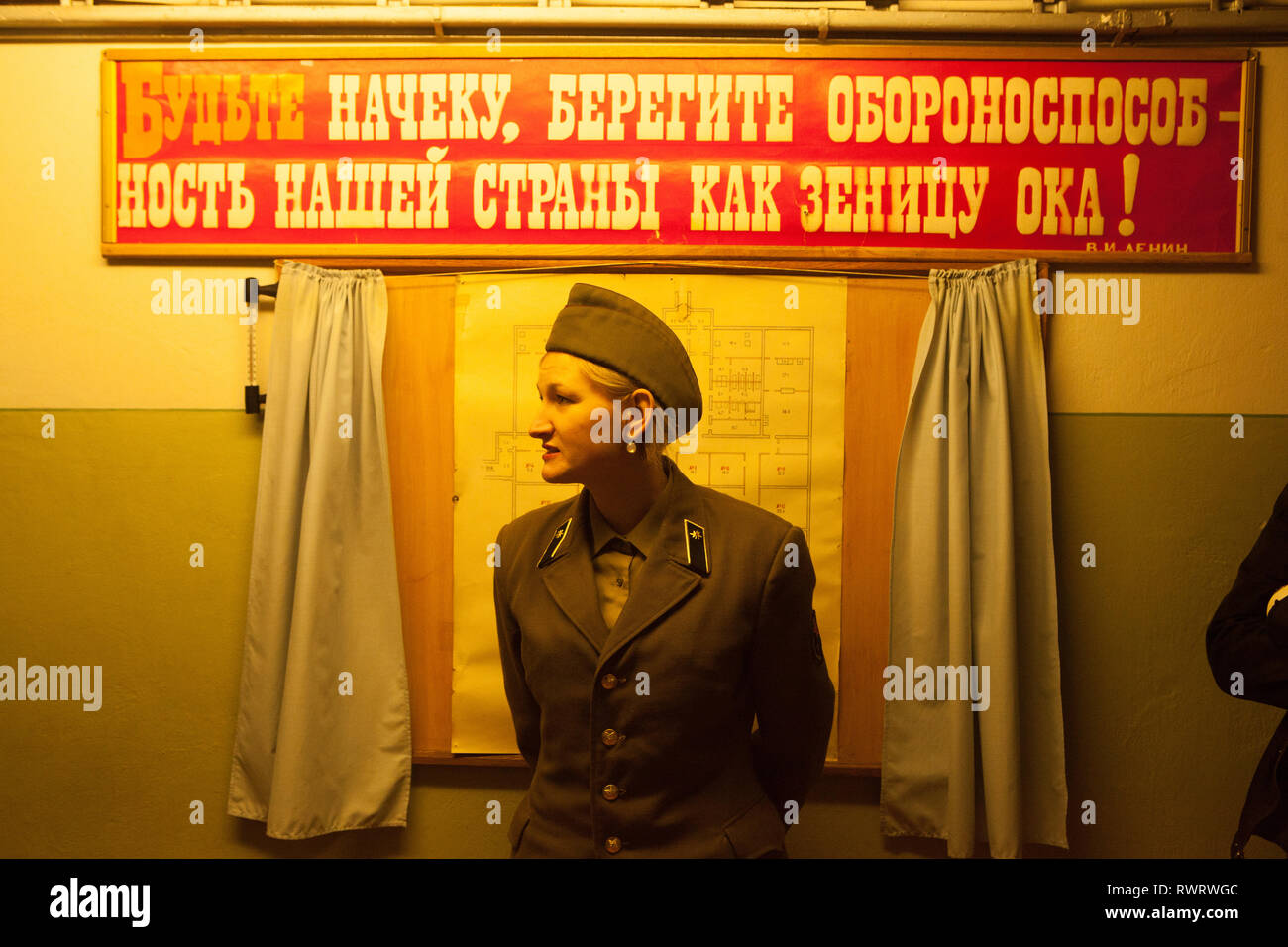Weibliche Führung in Uniform vor Bunker, Līgatne, Lettland Stockfoto