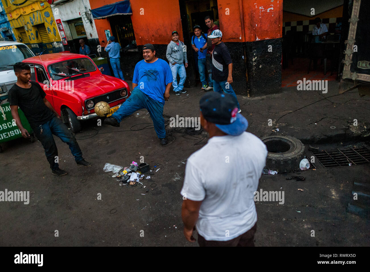 Kolumbianische Automechaniker spielen Straßenfußball während der Arbeitspause im Barrio Triste, Medellín, Kolumbien. Stockfoto