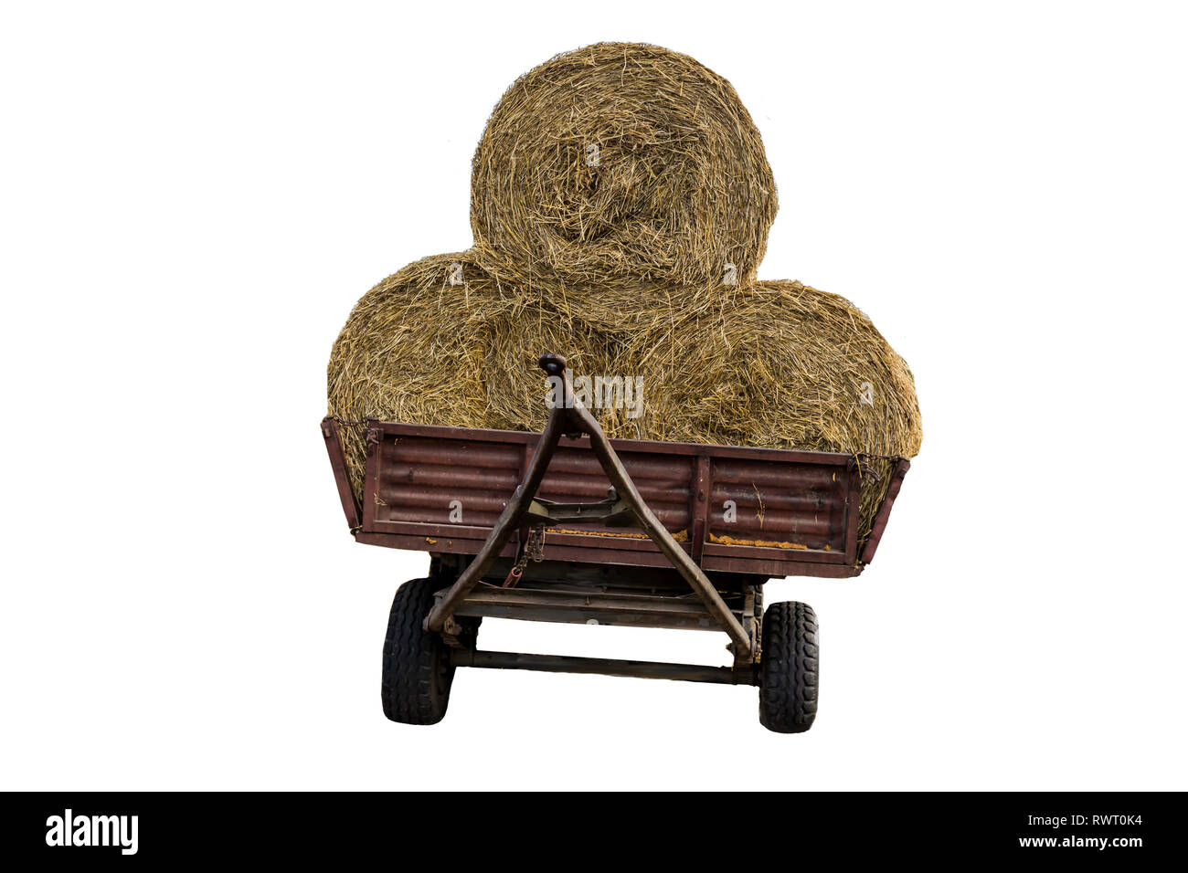 Rundballen Stroh, mit einem Netz, auf einem Traktor Anhänger geladen. Stroh ist ein weit verbreitetes Material für Vieh Betten auf dem Bauernhof. Isoliert Foto. Stockfoto