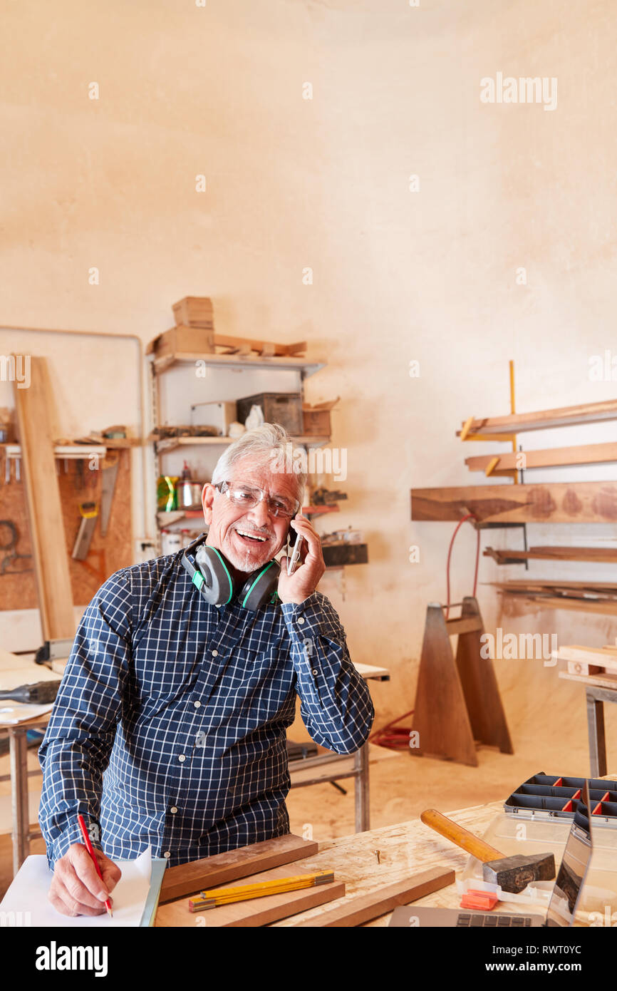 Handwerker Master und Senior Chef sprechen am Telefon als Customer Service Stockfoto