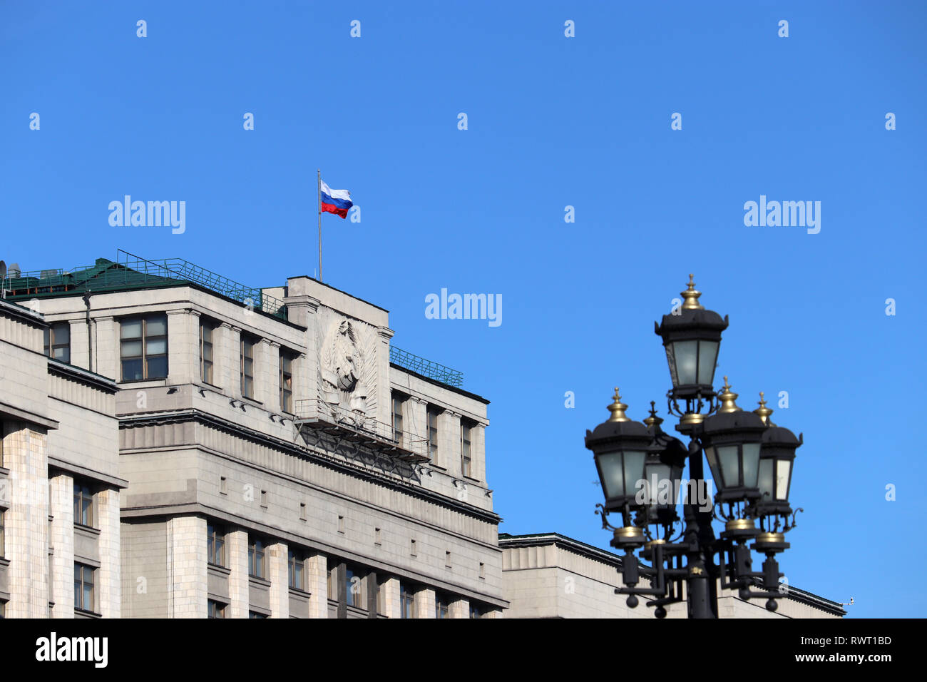 Russische Flagge auf dem Parlamentsgebäude in Moskau gegen den blauen Himmel. Russischen Behörde, Fassade der Staatsduma Russlands mit sowjetischen Wappen Stockfoto