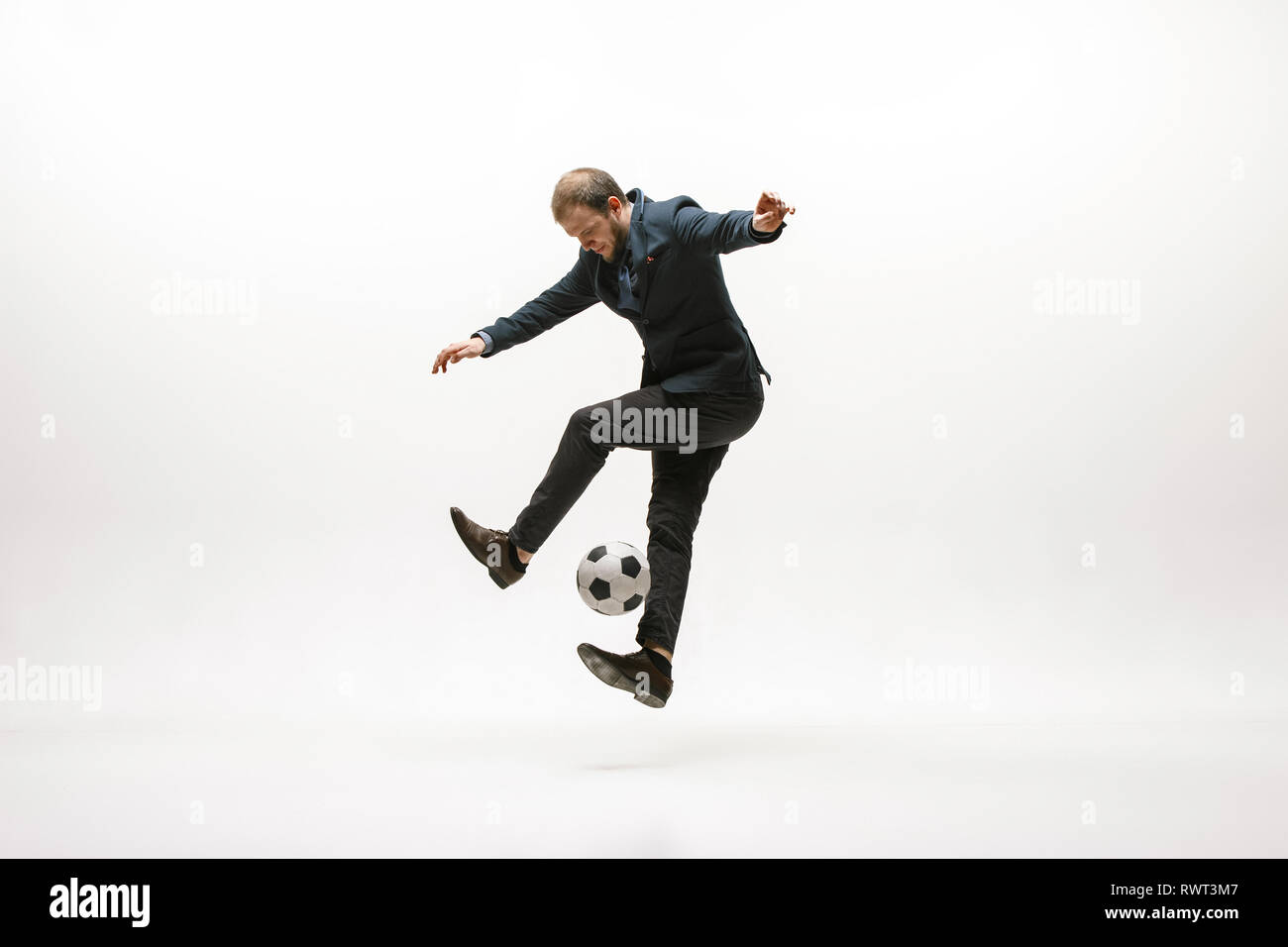 Geschäftsmann mit Fußball-Ball im Amt. Fußball Freestyle. Konzept der Balance und Beweglichkeit im Geschäft. Manager Aqua-lounge Tricks auf weißem studio Hintergrund isoliert. Stockfoto