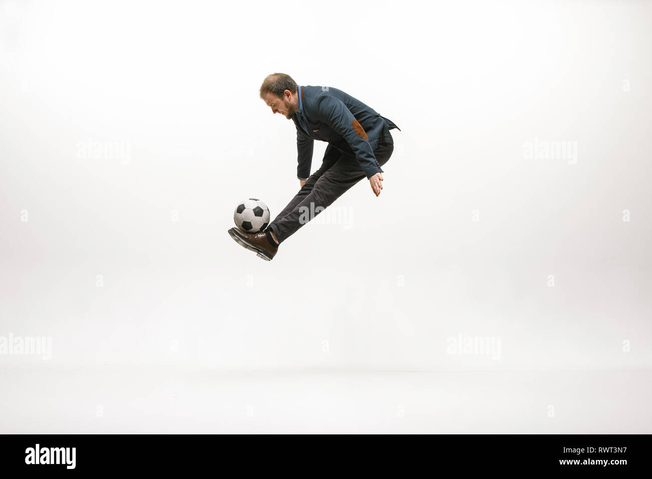 Geschäftsmann mit Fußball-Ball im Amt. Fußball Freestyle. Konzept der Balance und Beweglichkeit im Geschäft. Manager Aqua-lounge Tricks auf weißem studio Hintergrund isoliert. Stockfoto