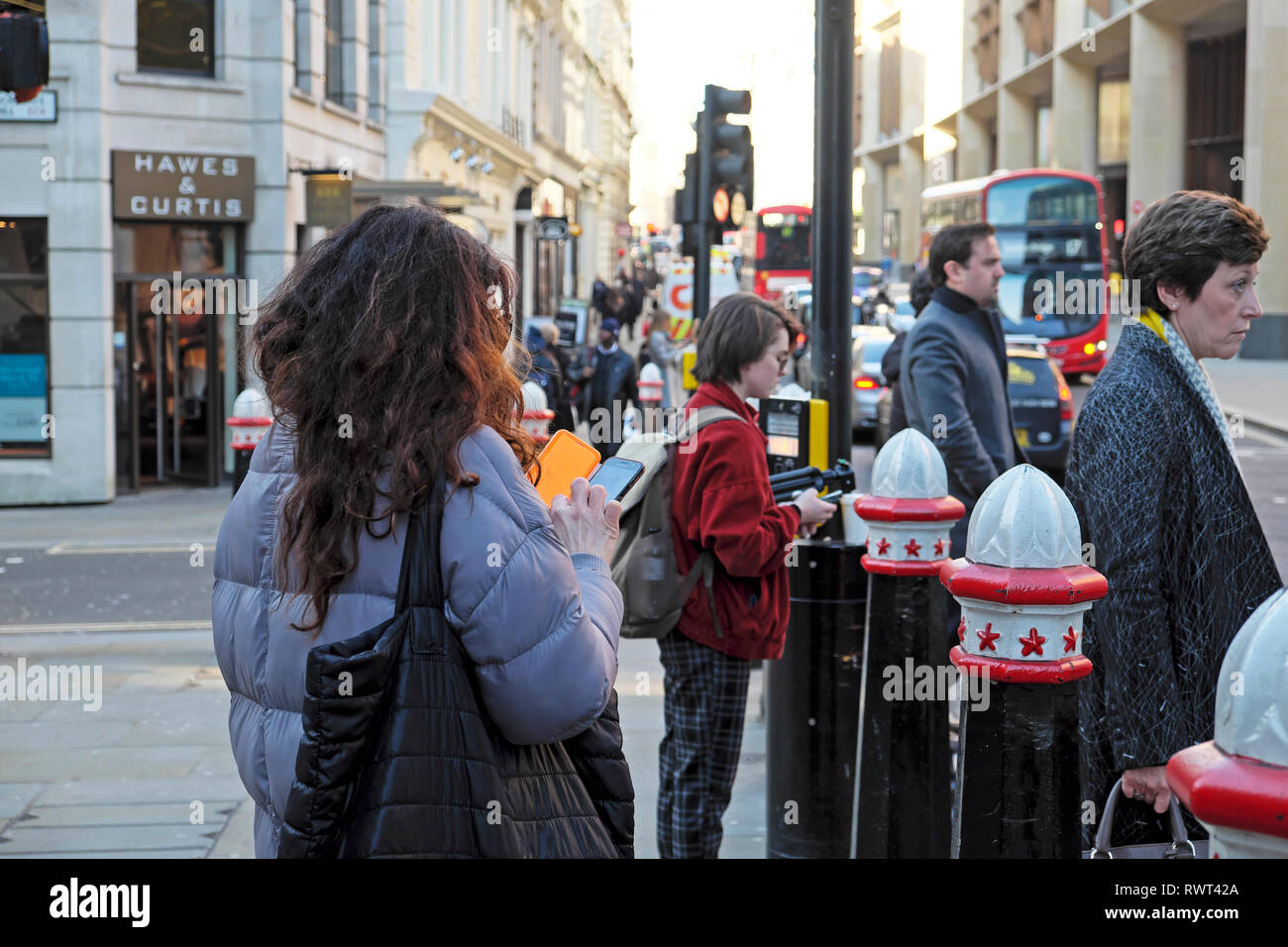 Ein Blick auf die Frau, die den Versand von SMS auf dem Telefon in Masse warten auf Ampel auf der Cannon Street in der City von London England UK Europa KATHY DEWITT Stockfoto