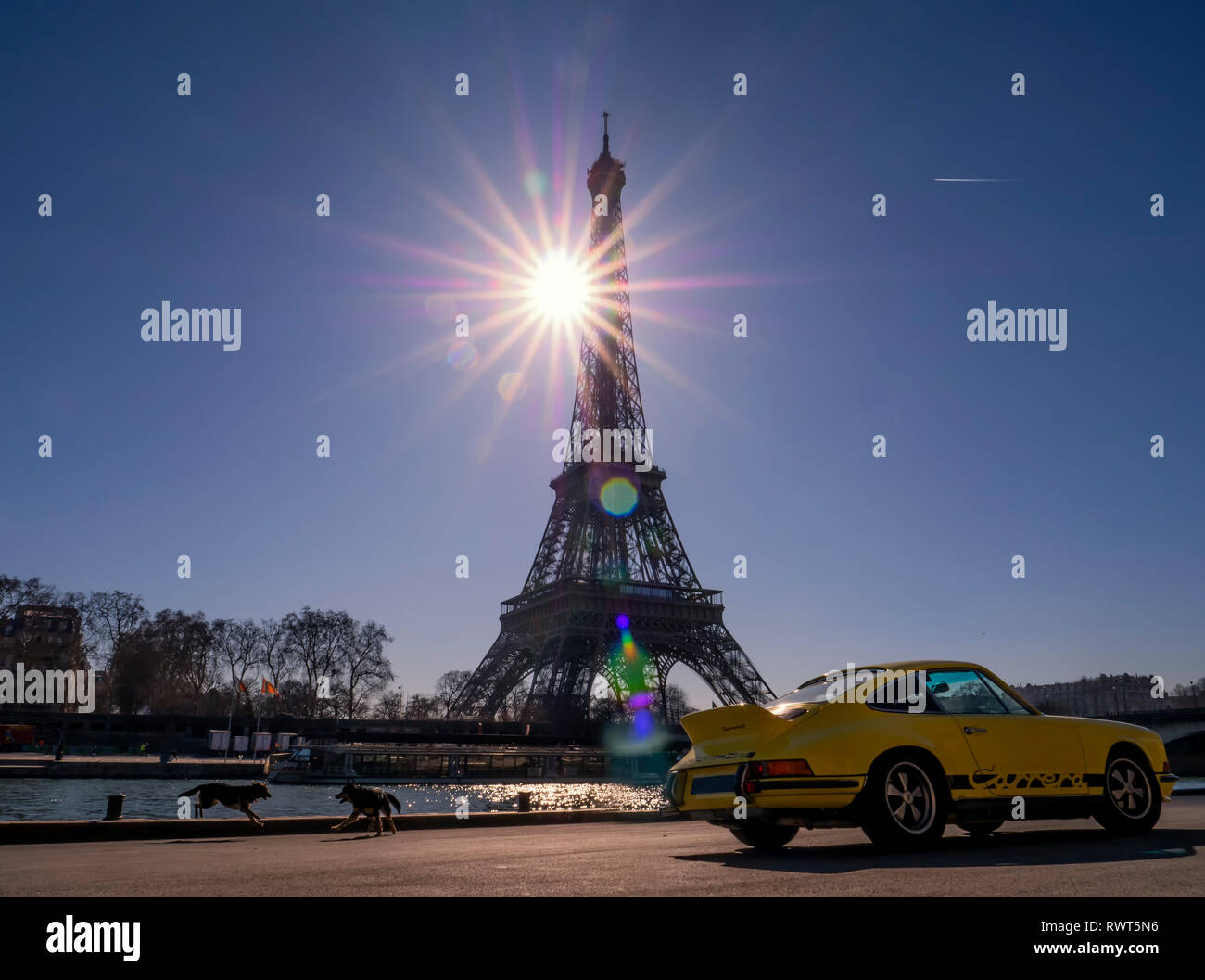 Der Eiffelturm mit einem gelben schnelles Auto im Vordergrund. Stockfoto