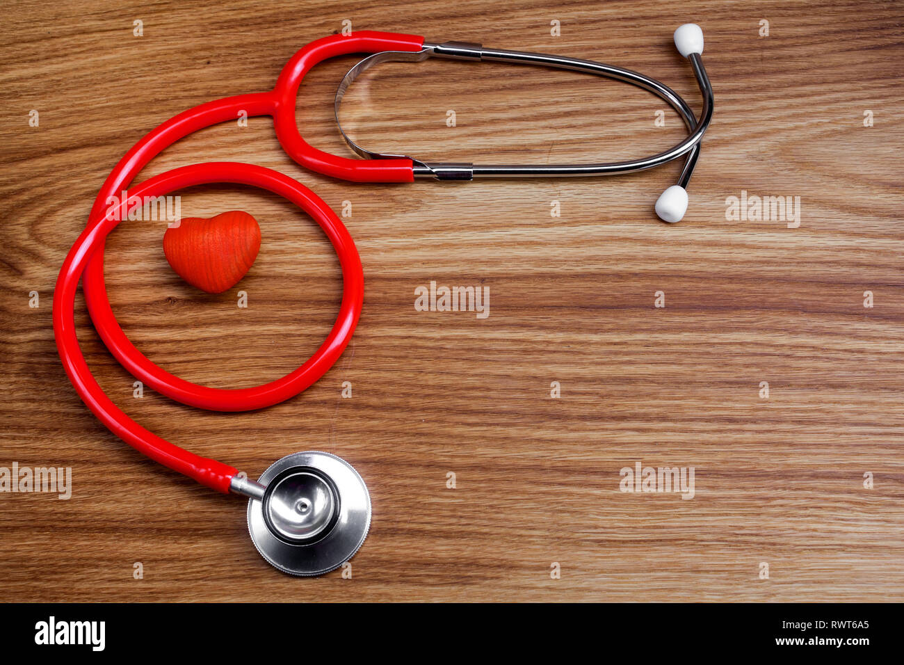 Stethoskop mit roten Herzen auf ein Holz Hintergrund Stockfoto