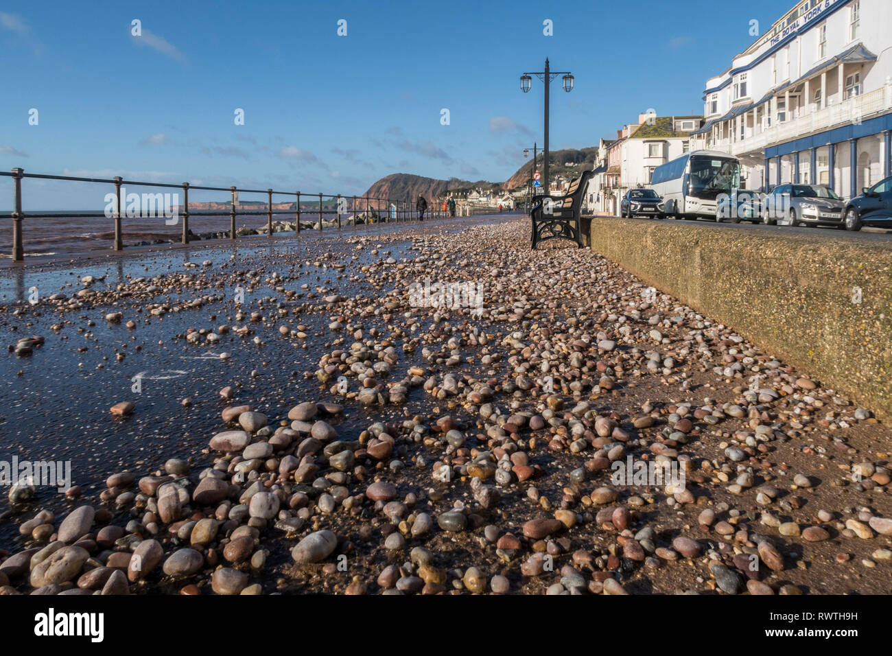Kiesel und Schiefer vom Strand auf die Strandpromenade geworfen in Sidmouth durch einen Sturm. Stockfoto