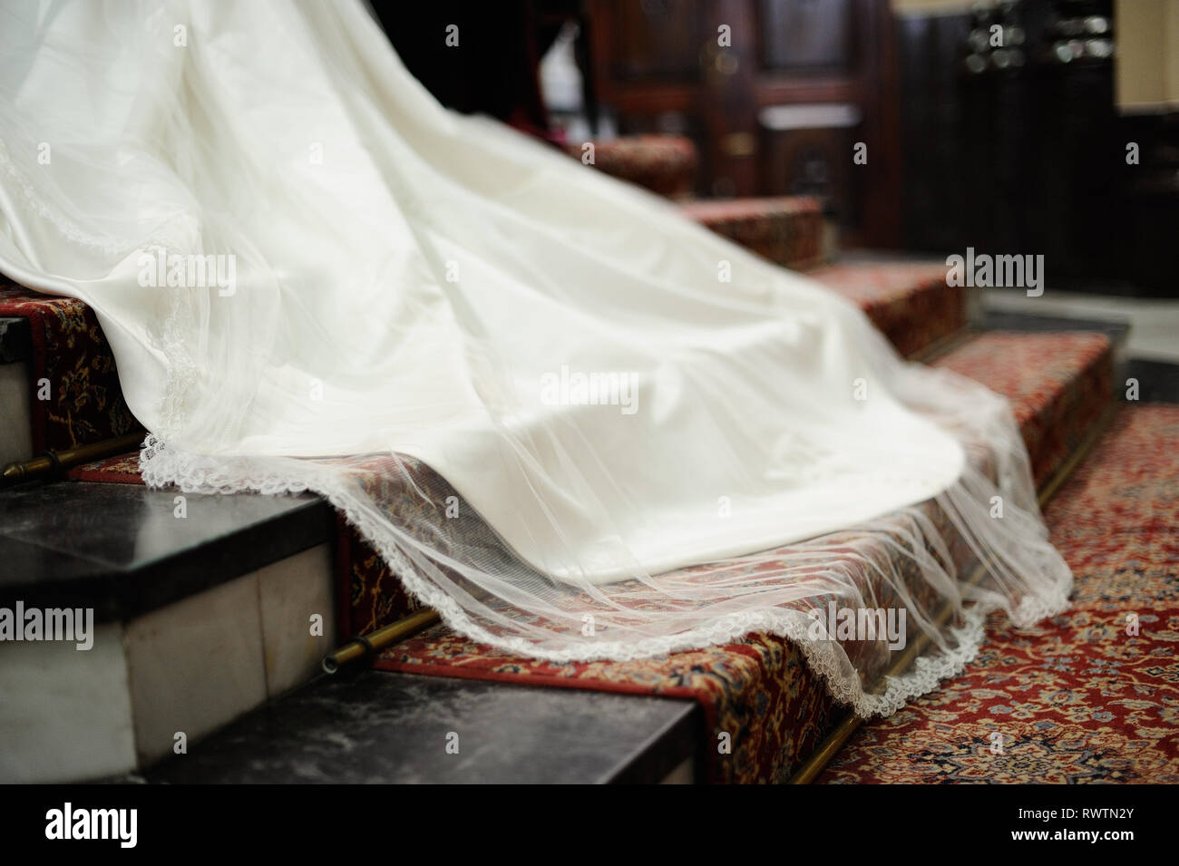 Schwanz der weißen Hochzeit Kleid auf dem roten Teppich mit Schritte Stockfoto