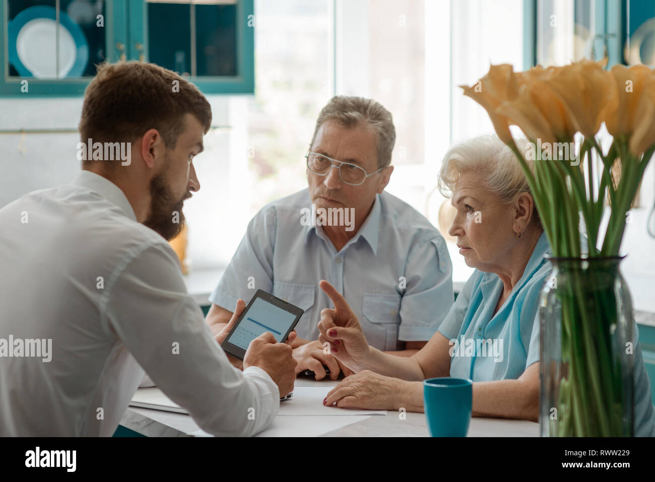 Senior Paar diskutiert mit Finanzberater zu Hause, um Fragen über Zukunft. Stockfoto