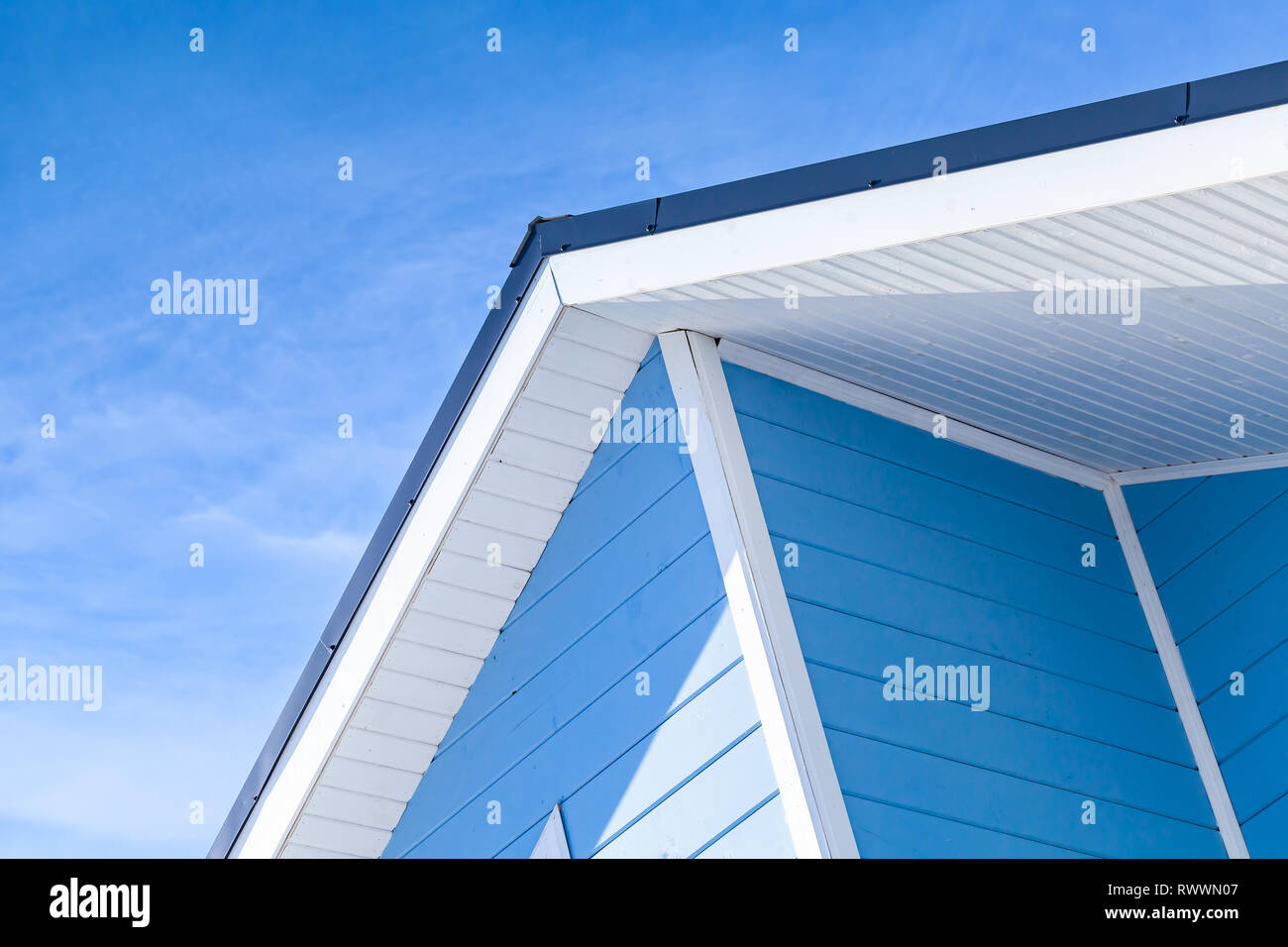 Neue blau-weiße Holzhaus Fassade Fragment mit Dach unter freiem Himmel Stockfoto