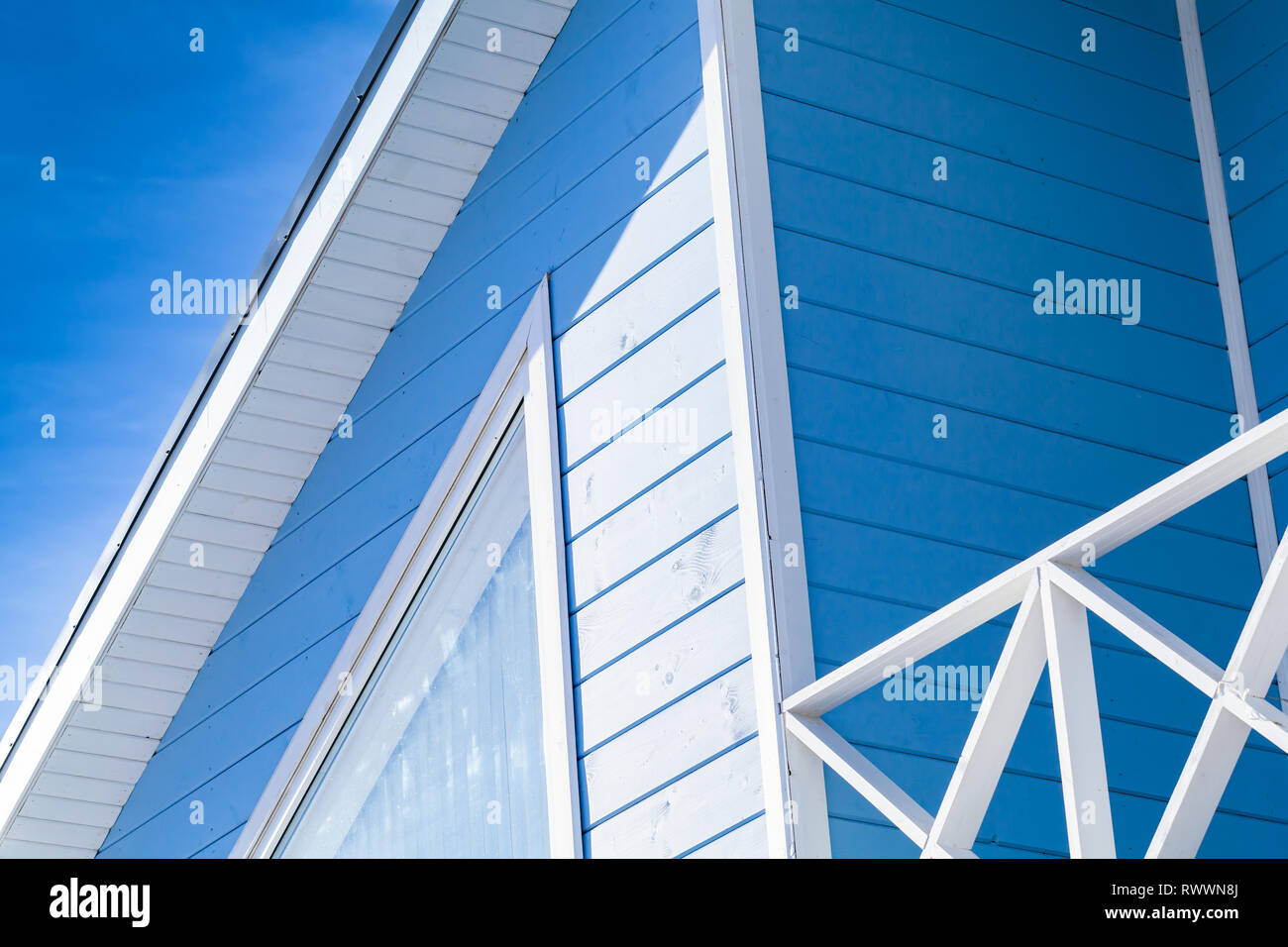 Neue blau-weiße Holzhaus Fassade Fragment mit Dach und Balkon Stockfoto