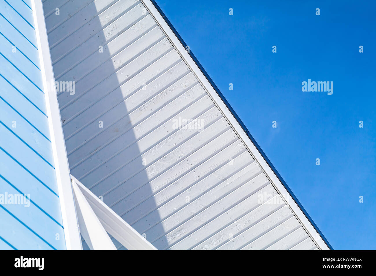 Neue blau-weiße Holzhaus Fassade Fragment unter klaren Himmel Stockfoto