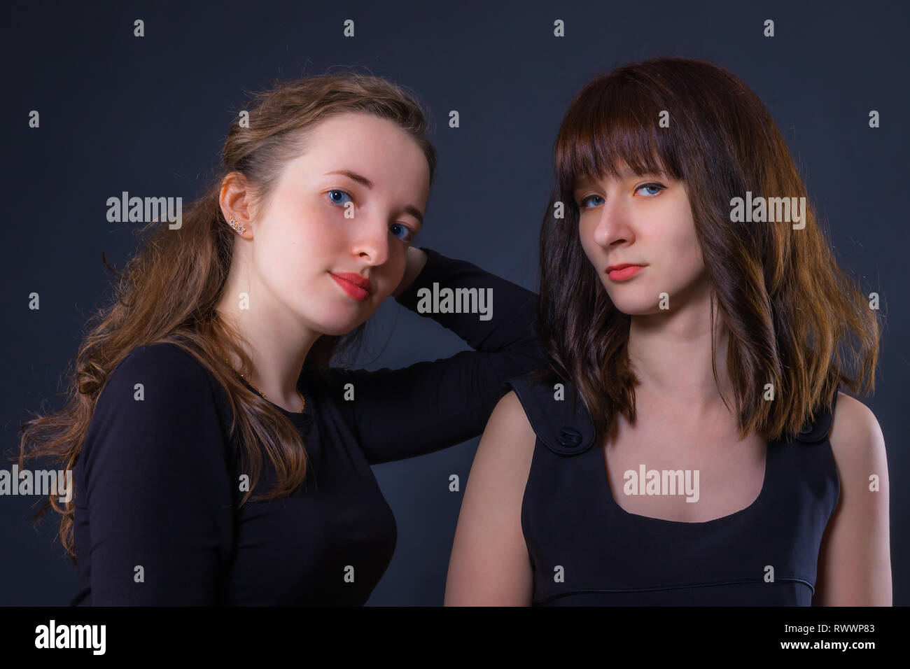 Gruppe Porträt von zwei Mädchen auf einem dunklen Hintergrund Stockfoto