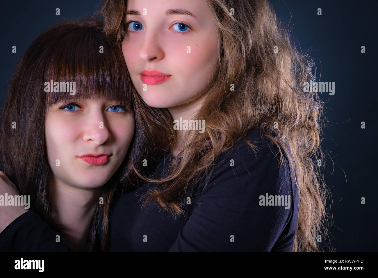 Gruppe Porträt von zwei Mädchen auf einem dunklen Hintergrund Stockfoto