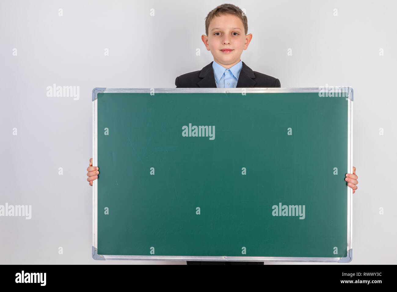 Eine lächelnde Junge hält einen Bulletin Schiefertafel mit leeren Raum. Stockfoto