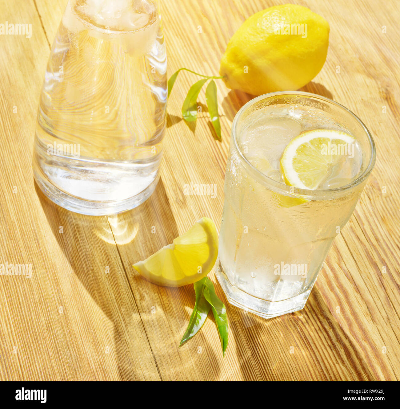 Mineralwasser mit Zitrone auf Holz- Hintergrund im Sommer Stockfoto