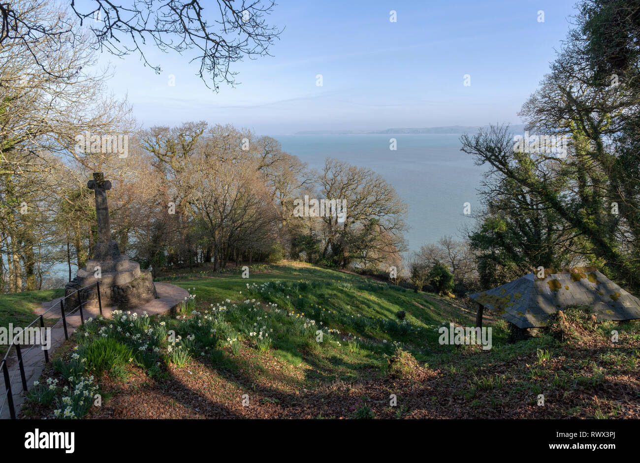 Clovelly, North Devon, England, UK. Februar 2019. Ein Kriegsdenkmal und Frühlingsblumen bei einem Picknick Ort namens Mount Pleasant mit Blick auf die Küste. Stockfoto