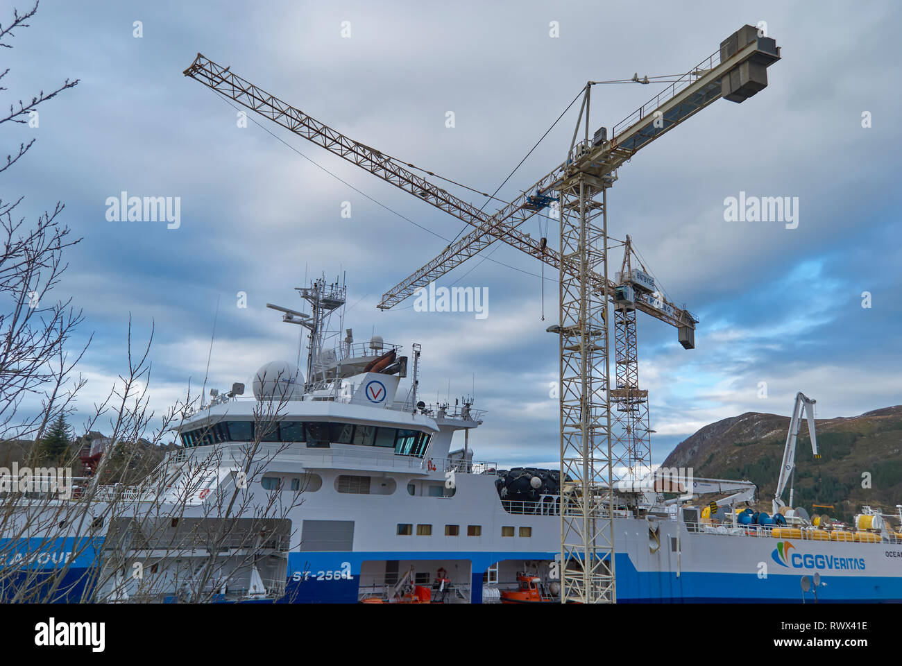 Gekreuzt Containerkrane über eine seismische Forschung Schiff im Batbygg Werft in Maloy auf einem Winter morgen, Norwegen Stockfoto