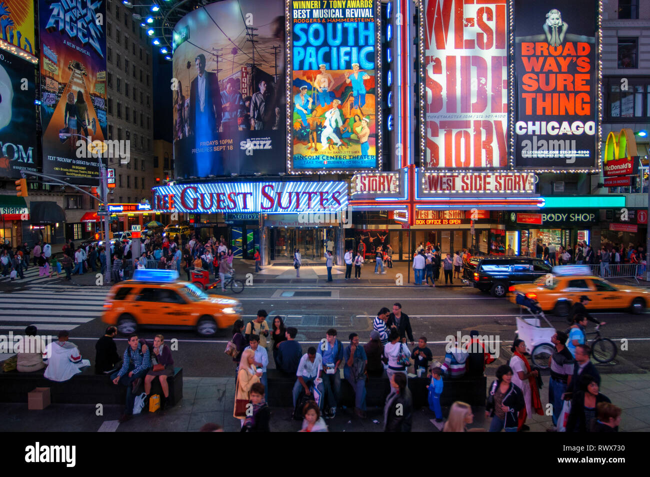 Helles Neon signage blinkt über Massen und taxi Datenverkehr, der an den Times Square der Veranstaltungsort der berühmten New. Stockfoto