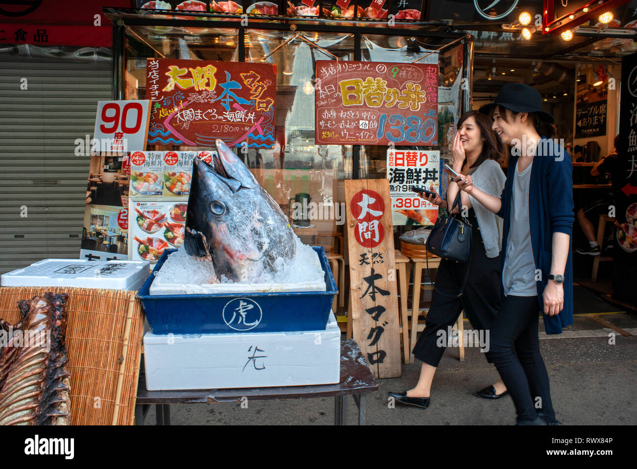 Kleine schwarze Sushi Restaurant in der Nähe des riesigen Tsukiji Fischmarkt in Tokio, Japan, eine riesige Thunfische und Bilder von Mahlzeiten, und ihr Menü Stockfoto