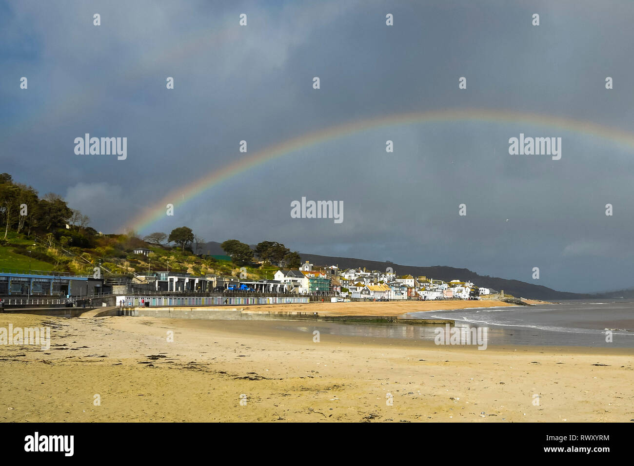 Lyme Regis, Dorset, Großbritannien. 7. März 2019. UK Wetter. Ein Regenbogen Bögen über die Küstenstadt Lyme Regis in Dorset an einem Nachmittag Sonnenschein und Duschen. Foto: Graham Jagd-/Alamy leben Nachrichten Stockfoto