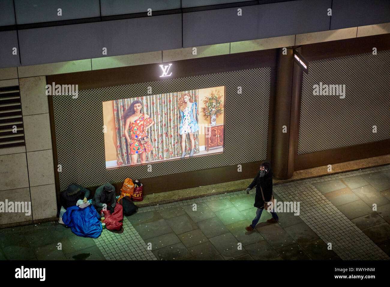 Obdachlose Bettler außerhalb louis vuitton Designer Store in Selfridges Manchester City Centre Stockfoto