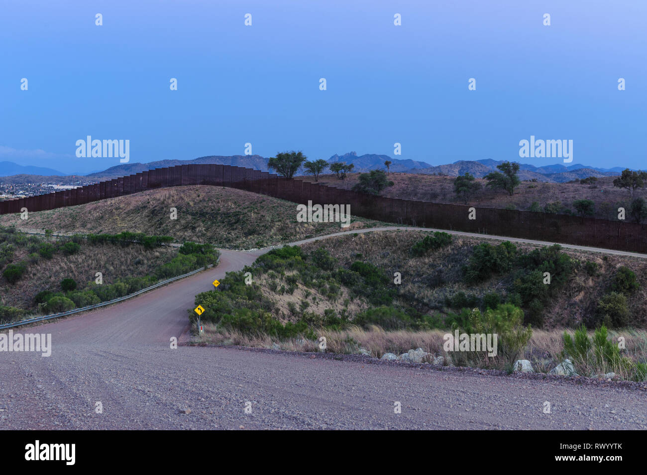 Uns Grenzzaun zwischen sanften Hügeln in der Dämmerung, im Süden von westlich von Mariposa Einfuhrhafen, Nogales Arizona, April, 2018 Stockfoto