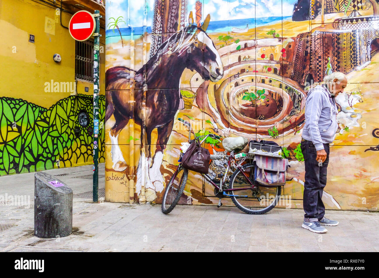 Ein Mann, der vor einer Graffiti-Wand steht, Szene in Valencia, der Altstadt, der Straße im Stadtteil El Carmen, Spanien Stockfoto