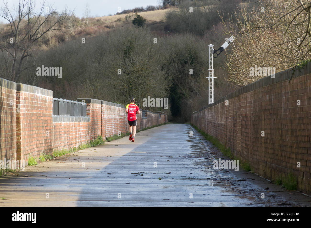 Läufer auf dem restaurierten Hockley Viadukt, eine stillgelegte Eisenbahnviadukt in der Nähe von Winchester, Hampshire, UK Stockfoto