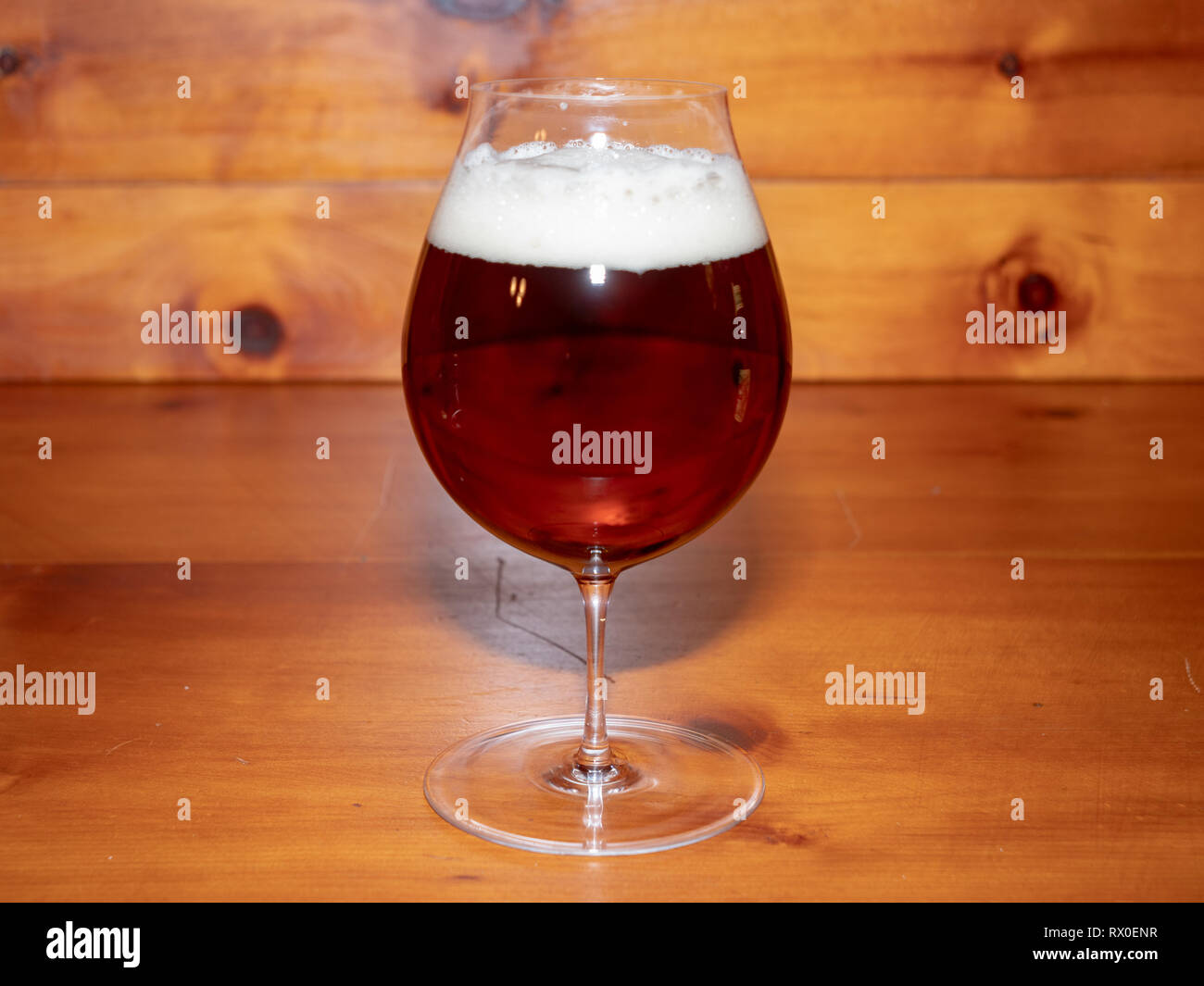 Erfrischend, Amber Ale oder Bier in einer Tulpe Glas auf einem Holz Hintergrund Stockfoto