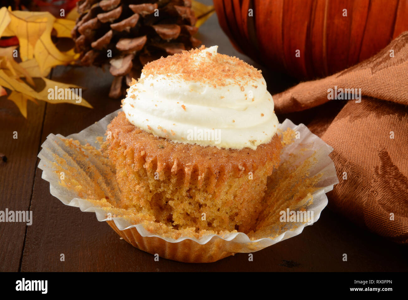 Ein Kürbis Cupcake an einem Feiertag Tabelle mit Blätter im Herbst Stockfoto