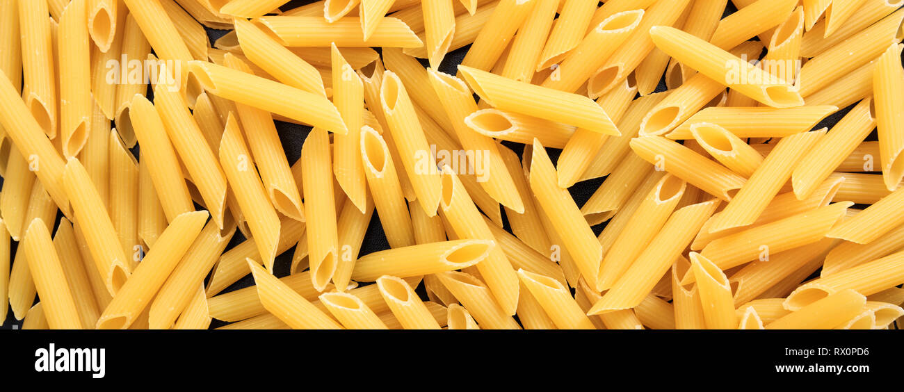 Italienisches Essen. Ungekocht trocken Penne Rigate Form pasta Textur Hintergrund, Banner Stockfoto